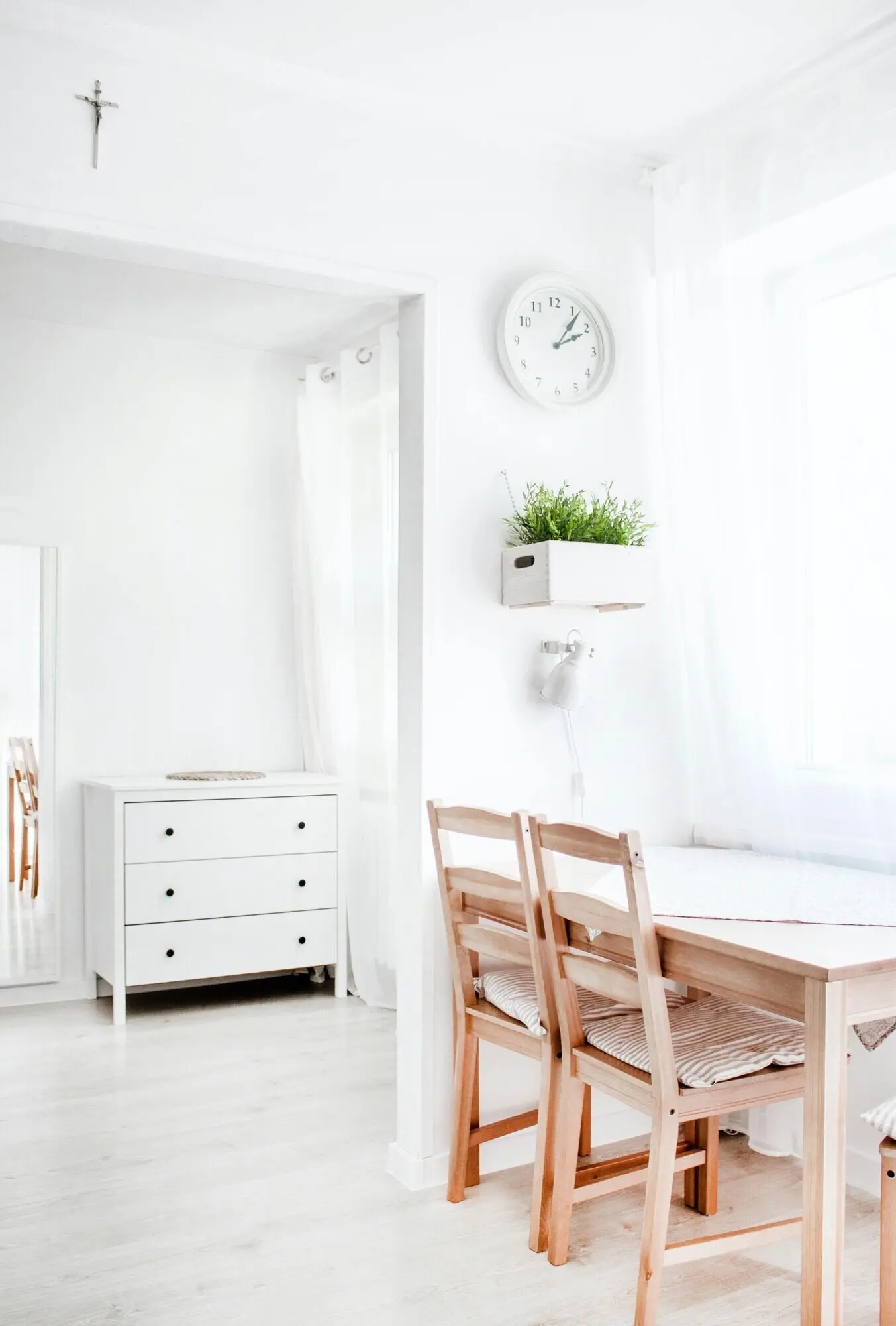 Portrait-oriented photograph of a white interior with wooden elements.